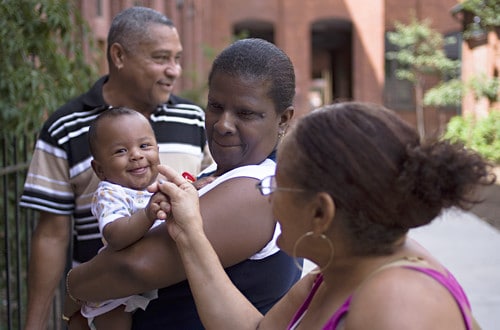 Family members surrounding a smiling baby